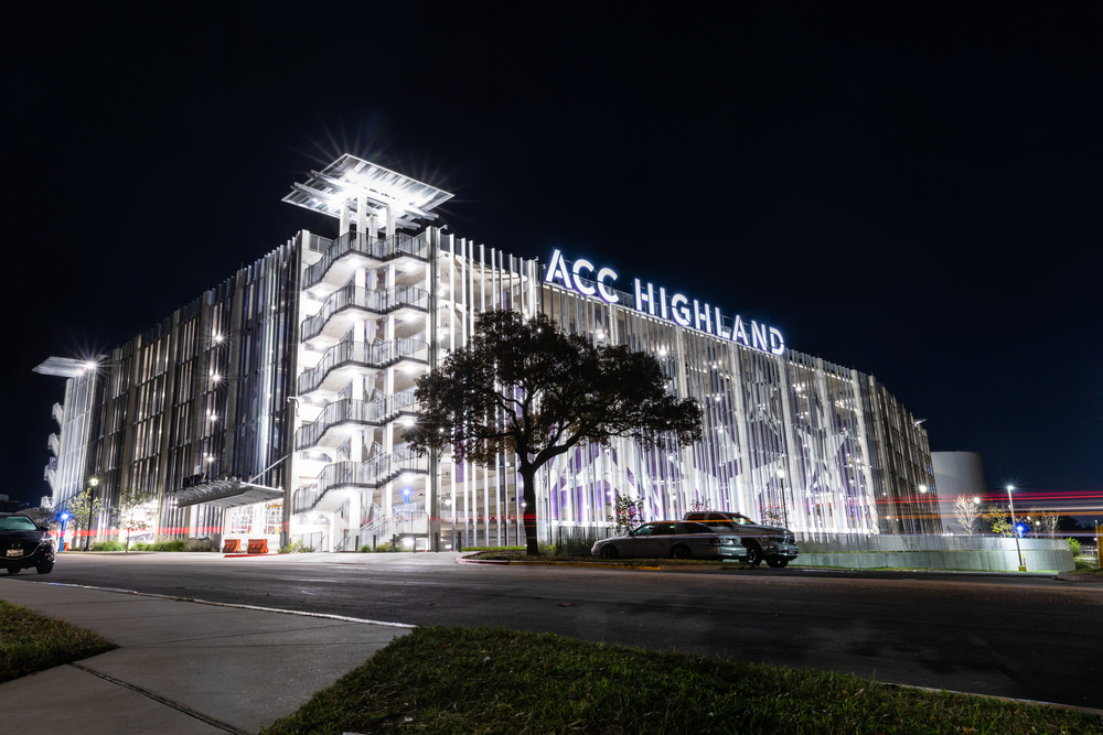 Highland campus at night with white lights.
