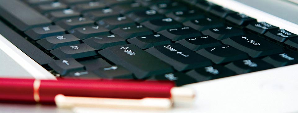 Closeup of a keyboard and red pen.