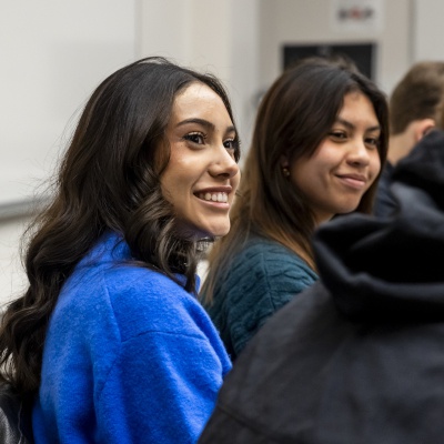 Two female students smiling in conversation