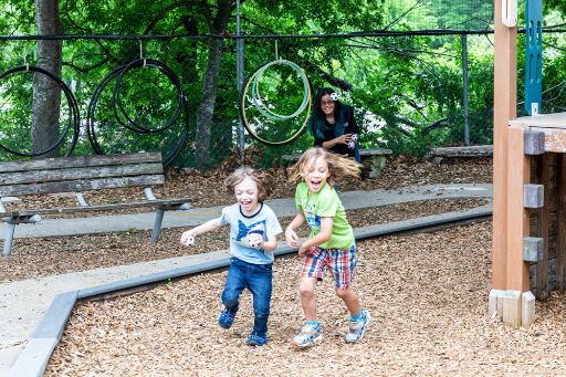 6 Tips for Student Parents to Succeed in College | Austin Community College District two children play on a playground while a smiling woman watches in the background