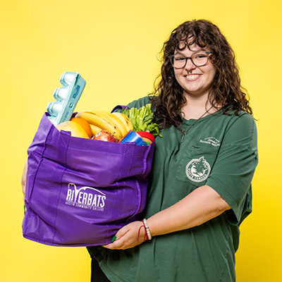 ACC student holding a bag of free groceries.